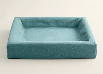 Een Bia Bed met een Oceanblauwe Skanör hoes gemaakt van zachte meubelstof.
