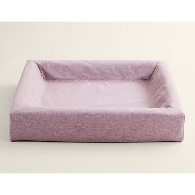 Een Bia Bed met een roze Skanör hoes gemaakt van zachte meubelstof.