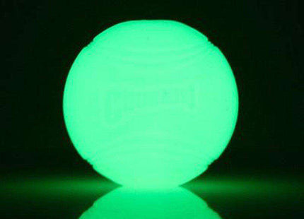 Een Chuckit! - Max Glow Ball op een zwarte achtergrond straalt een groene gloed uit.