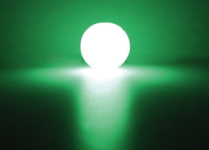 Een Chuckit! - Max Glow Ball, een groene bal van lichtgloeiend materiaal, opvallend op een donkere achtergrond.