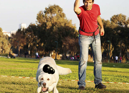 Een man en een hond spelen frisbee met een duurzame Kong - Extreme.