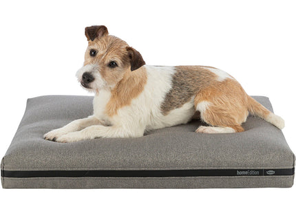 Een kleine hond loungen op een Trixie - Hondenmatras CityStyle - Home Edition grijze hondenmand.
