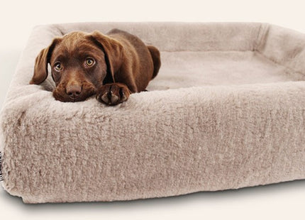 Een bruine hond luierend op een knus Bia Bed - Fleece Overtrek.