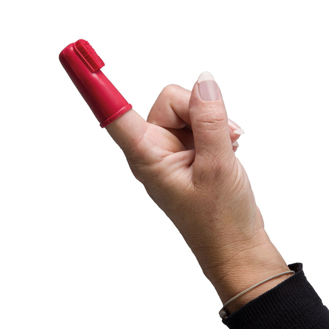 Een vrouwenhand die een rode nagelknipper vasthoudt, benadrukt het belang van tandheelkundige zorg met Beaphar - Vinger-Tandenborstel - 2 ST.