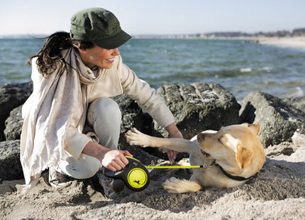 Vrouw speelt met hond op het strand, Flexi - Rollijn New Neon L in gebruik.