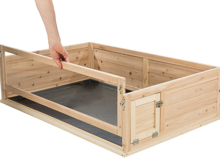 Voorzichtig opent iemand een houten kist met daarin het Trixie - Indoor Knaagdierverblijf, een geschikt leefgebied voor cavia's.